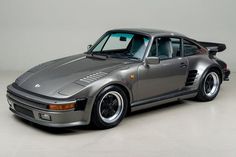 this is an image of a silver porsche turbo car in the studio with its hood down