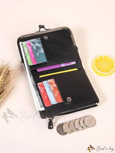 an open wallet sitting on top of a table next to some coins and a lemon