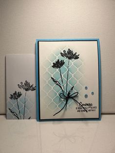 two cards with flowers on them sitting next to each other in front of a wall