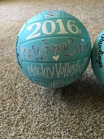 two blue volleyballs sitting on top of a carpeted floor next to each other