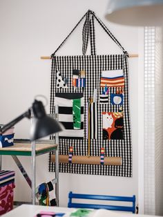 a room with a chair, desk and wall hanging