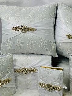 white pillows with gold trim and sashes on them