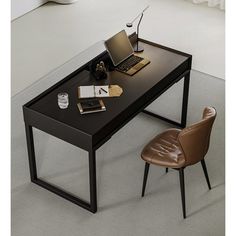 an office desk with a laptop on it and a chair in front of the desk