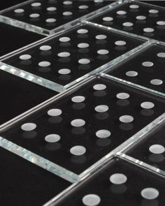 the black and white polka dot glass tiles are arranged in rows on top of each other