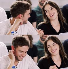 a man and woman sitting next to each other in front of a crowd with their hands on their chins