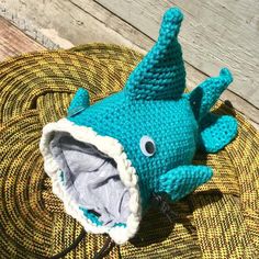 a crocheted stuffed animal laying on top of a woven tablecloth covered floor