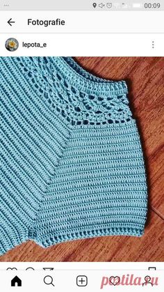 a blue knitted sweater sitting on top of a wooden floor