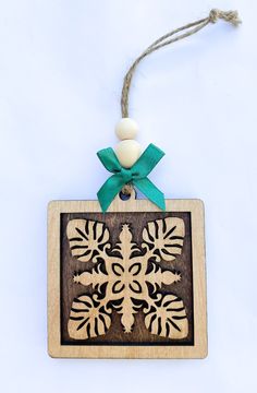 a wooden ornament with a green bow on it