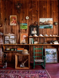 a room with wooden paneling and pictures on the wall, including a green chair