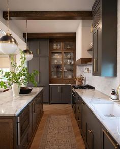 a kitchen with marble counter tops and wooden cabinets, along with an area rug on the floor