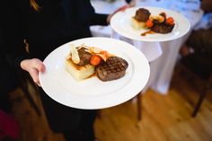 two white plates topped with food on top of a table