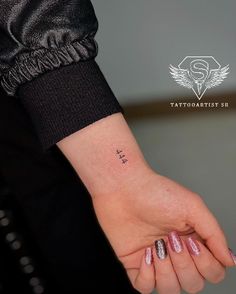 a woman's hand with a small tattoo on it