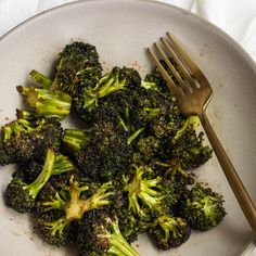 a white plate topped with broccoli and a fork