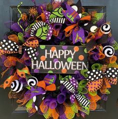 a halloween wreath with the words happy halloween written on it and decorated with colorful decorations