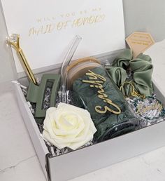 an open box with some items in it that say maid of honey and a white rose