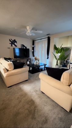 a living room filled with furniture and a flat screen tv mounted to the side of a wall