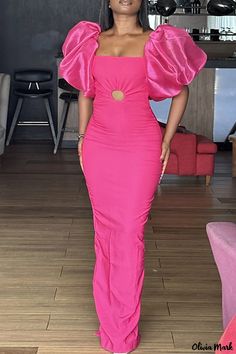 a woman in a pink dress posing for the camera