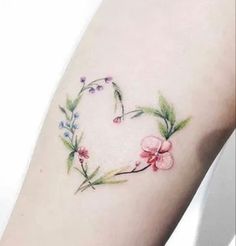 a woman's arm with flowers and leaves on the back of her leg,