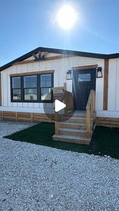 a mobile home with steps leading up to the front door