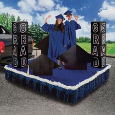 two graduates in graduation caps and gowns standing on top of blocks that spell out grad dad