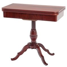 a small wooden table with two legs and a drawer on the top, sitting against a white background