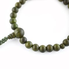 Green Lignum Vitae Wood Juzu Prayer beads Materials : Lignum vitae wood, Silk cord Diameter : about 10cm (not elastic) Head bead : about 16mm Main beads : about 11mm Handmade in Kyoto, JAPAN Lignum vitae wood is said to be the densest wood in the world, grows extremely slowly, and extremely rare, so it is called a "wooden jewel" and is prized.It has the characteristic of changing to a deeper green color over time. It has been treated like a jewel, since ancient times It was only allowed to have by aristocrats. In Japan, Buddhists have Prayer beads (Juzu, Nenju). Kyoto is famous as a producing center of Prayer beads. Prayer beads are a traditional tool used to count the number of times a mantra is recited, breaths while meditating, counting prostrations, or the repetitions of a buddha's nam Adjustable Wooden Beaded Bracelet With 8mm Beads, Adjustable Wooden Bracelet With 8mm Beads, Adjustable Wooden Beaded Bracelets With 8mm Beads, Adjustable Wooden Beaded Bracelets For Meditation, Spiritual Wood Round Beads Jewelry, Adjustable Green Wooden Beads, Handmade Natural Wood Beaded Bracelets, Handmade Wooden Beaded Bracelets For Meditation, Wooden Round Beads Jewelry For Meditation