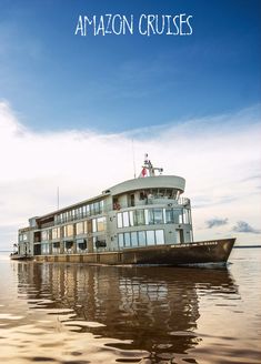 a large boat floating on top of a lake under a blue sky with the words amazon cruises above it