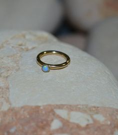 ⋙ 14kt Gold Filled light blue opal tragus ring.⋙ This listing is for one earring.⋙ Available gauges for the ring: 20g; 18g; 16g.⋙ Please note: the less gauge number, the thicker ring is.⋙ Available interior (inner) diameters: 7mm; 8mm; 9mm; 10mm⋙ Available gemstones: ruby; lapis lazuli; black onyx; emerald; light blue opal; garnet; white opal; kiwi green opal; amethyst; aqua blue cz; clear cz; black-red opal; turquoise; blue sapphire⋙ Measurements:⋙ The stone is 2mm in diameter⋙ ⋙ I will put you Minimalist Teardrop Stackable Jewelry, Yellow Gold Stackable Cartilage Earrings As Gift, Stackable Yellow Gold Cartilage Earrings As Gift, Adjustable Internally Threaded Jewelry For Anniversary, Dainty Teardrop Internally Threaded Jewelry, Stackable Round Cartilage Earrings For Gifts, Stackable Round Cartilage Earrings As Gift, Gift Round Stackable Cartilage Earrings, 14k Gold Stackable Cartilage Earrings For Gift