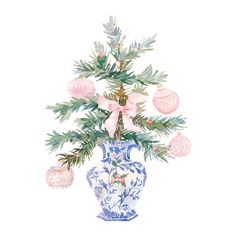 a blue and white vase filled with pink ornaments on top of a table next to a tree