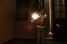 a young boy holding sparklers in his hands