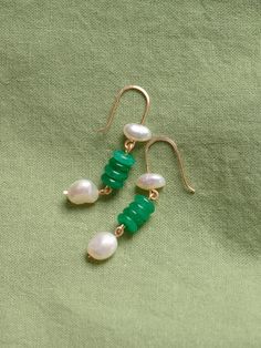 Green onyx and freshwater pearl suspended on earring backs made of tarnish resistant silver-plated copper. Rubber backs are provided. All pieces by Studio Greco are made to order by hand, using natural stones. Because each stone is unique no two pieces will look exactly the same. The precise color, shape, and size of stones cannot be guaranteed. Stones and pearls may contain natural imperfections. For longevity all pieces should be treated delicately and handled with care. Green Onyx Drop Earrings, Green Onyx Earrings For May Birthstone, Green Pearl Charm Drop Earrings, Green Dangle Pearl Earrings For Pierced Ears, Jade Pearl Drop Earrings As Gift, Green Drop Earrings With Pearl Charm, Green Onyx Dangle Jewelry, Green Earrings With Natural Stones As Gift, Green Dainty Dangle Earrings