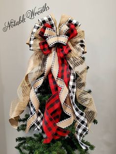 a christmas tree decorated with burlocks and plaid ribbon for the holiday season is shown