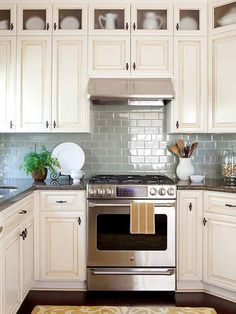 a kitchen with white cabinets and silver appliances