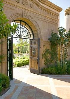 an open door leading into a garden with trees and bushes on either side of it