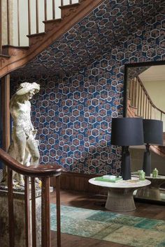 a living room filled with furniture and a stair case in front of a wall mounted mirror