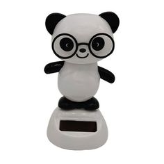 a white and black panda bear sitting on top of a electronic scale with glasses on it's face