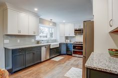 Kitchen remodel with white upper cabinets, a grey backsplash, light granite countertops, new vinyl plank flooring, and farm sink under the bay window Sink Kitchen, Farmhouse Sink Kitchen