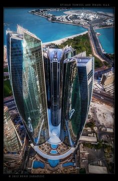 an aerial view of two tall buildings in the middle of a large body of water