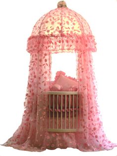 a baby crib with pink flowers on it and a canopy over the bed that is covered in netting