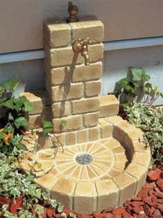 a fountain made out of bricks in the garden