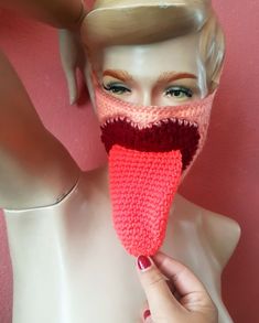 a mannequin head wearing a knitted scarf with an open mouth and tongue