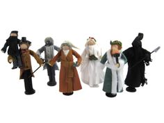 five toy figurines are lined up in a row on a white background, one is wearing a long coat and the other has a top hat