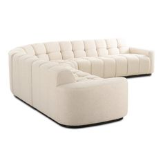 a large white couch sitting on top of a wooden floor next to a chair and ottoman