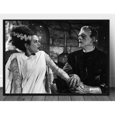 a black and white photo of two people dressed as dracula and the woman is holding her hand