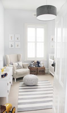 a baby's room with white walls and furniture