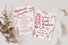 two red and white wedding stationery cards sitting on top of each other next to a plant