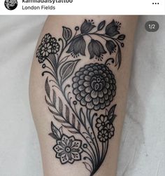 a black and white flower tattoo on the leg