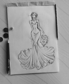 a drawing of a woman in a long dress on a piece of paper next to some buttons