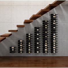 the wine bottles are lined up on the wall next to the stairs in the room