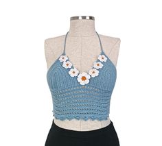 a mannequin wearing a blue and white top with flowers on the neckline